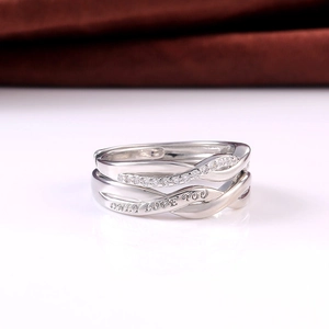 Detail of silver couple rings showing the Only Love You engraving and intertwined design
