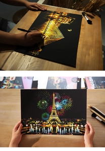 Close-up of DIY scratch art kit showing Eiffel Tower and Louvre city night views