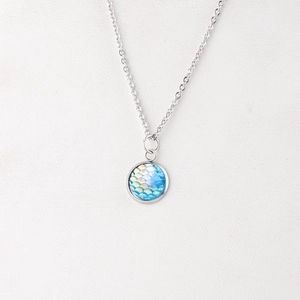 Macro detail of 12mm mermaid scale pendant on a mirror polished stainless steel chain