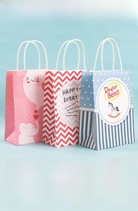 Detailed view of colorful cartoon kraft gift bags with white rope handles and patterns