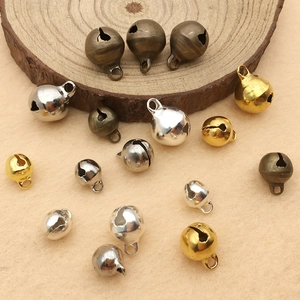 Close-up of vintage alloy bells in bronze gold and silver on a wooden display piece