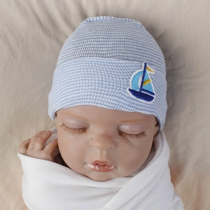 Detail of baby knitted hat with blue and white stripes and sailboat embroidery