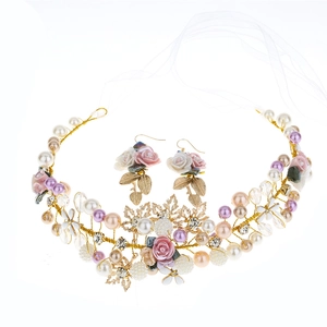 Handmade bridal jewelry set with pearl ceramic flowers and matching earrings on white background
