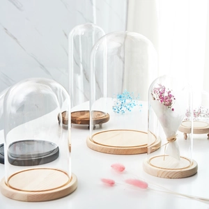 Transparent glass display domes with round wooden bases for preserving flowers and figurines