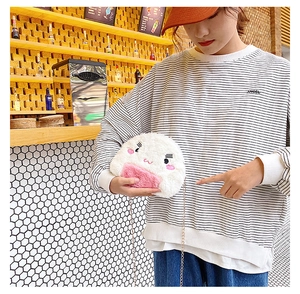 Close-up of cute plush rice ball crossbody bag with pink details and metal chain strap