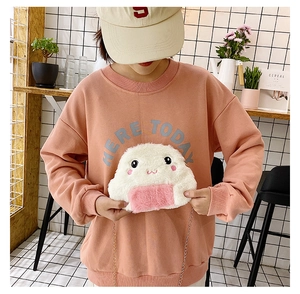 Detail of cute plush rice ball crossbody bag with gold chain strap on model