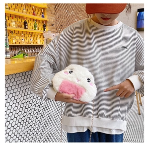 Detail of cute rice ball plush crossbody bag with chain strap on a female model