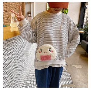 Detail view of the plush onigiri bag featuring a cute face and gold metal chain strap