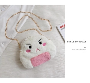 Close-up of cute plush crossbody bag with embroidery and gold chain on soft fur