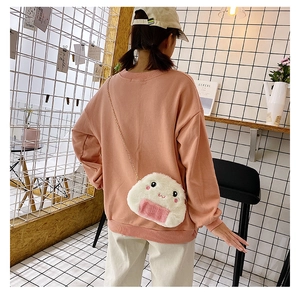 Model wearing a cute white plush rice ball crossbody bag with pink details and chain strap