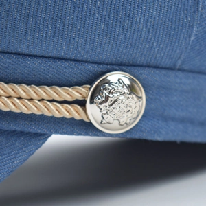 Retro blue corduroy octagonal hat featuring a vintage lion crest metal button and rope