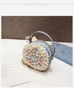 Detailed view of tweed girls' mini round bag with floral pearls and golden chain strap