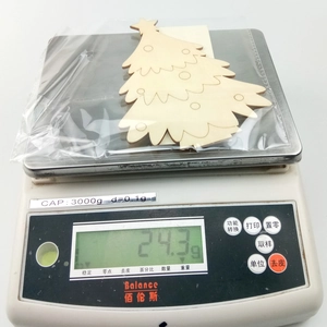 Detailed view of unfinished wooden Christmas tree ornaments being weighed on a digital scale