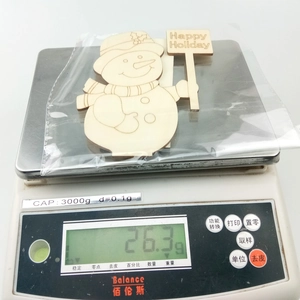 Macro view of a 26.3g DIY wooden snowman holiday decoration on a digital scale