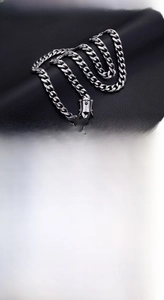 Detail of silver 15mm stainless steel curb chain set showing high-polish clasp and texture