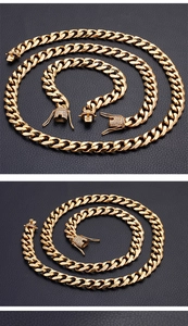 Macro shot of gold Cuban link jewelry set with CZ stones on dark leather background