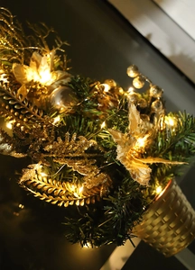 Golden Christmas basket with illuminated foliage, berries, and pine needles with warm LEDs
