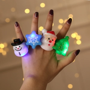 Detail shot of a hand wearing glowing LED Christmas rings with snowman and Santa shapes
