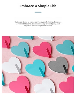 Close-up of heart-shaped stainless steel wall hooks in matte pink and silver finishes