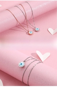 Detailed close-up of Evil Eye teardrop pendants in rose gold and silver finishes