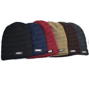 Set of six knitted beanies in multiple colors showing ribbed texture and metal fashion tag