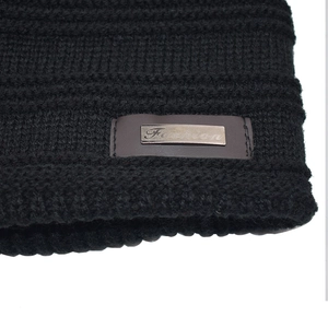 Warm black knit beanie with a stylish Fashion metal plaque and thick ribbed texture
