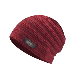 Close-up of wine red knitted beanie with wave texture and metallic Fashion label