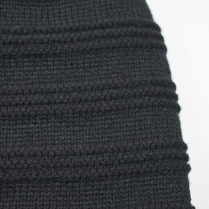 Close-up detail of black knitted winter hat featuring high-density ribbed texture
