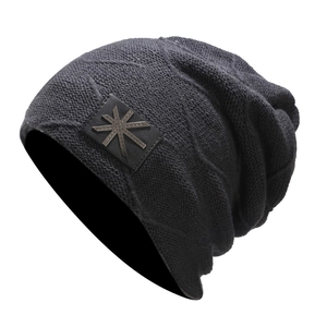 Detailed view of dark grey knit beanie featuring diamond texture and leather star patch
