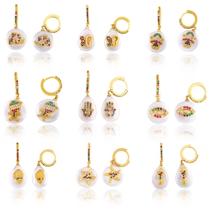 Collection of gold cross and animal earrings with colorful zircons and pearls on white