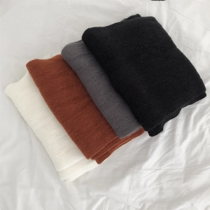 Detail view showing soft texture of folded autumn winter scarves in multiple colors.