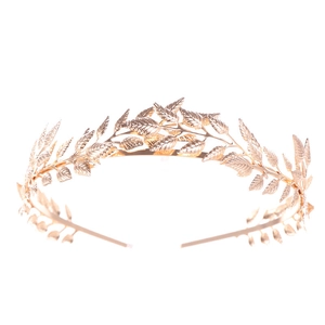 Detail of a golden metal leaf headband featuring delicate vine design with securing combs