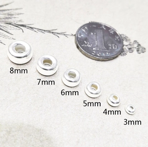 S925 Sterlingsilber Perlen in 3mm bis 8mm neben einer Münze zum Größenvergleich