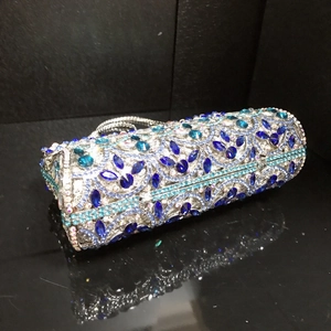 Macro view of blue crystal rhinestones on a cylindrical metal frame evening clutch bag