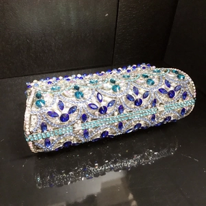 Detailed macro view of handcrafted blue and white rhinestones on cylindrical evening bag