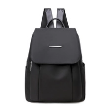 Rear view of black waterproof nylon backpack with adjustable straps and metal trim