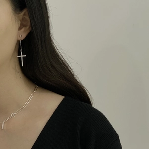 Close-up of 925 sterling silver cross earrings with pavé crystals on elegant model