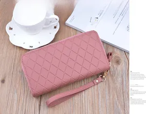 Detailed view of dusty pink checkered quilted long wallet with double zipper and wristlet