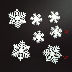 Macro detail of white plastic snowflakes in 1.7cm and 2.5cm sizes with soft texture