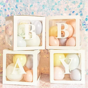 Detailed view of four transparent baby shower cubes with BABY letters and pastel balloons