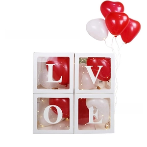 Close-up of LOVE transparent boxes with red balloons and LED lights for party decor
