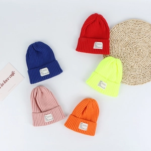 Colorful knitted ribbed beanie hats with fold-over cuff and labels in five bright colors
