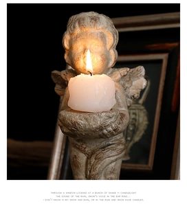 Macro view of vintage cupid angel candle holder with detailed wings and aged texture