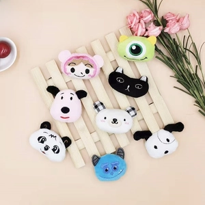 Close-up of adorable plush brooches with cartoon embroidery on wooden grid display