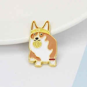 Macro shot of a Corgi dog enamel pin wearing a yellow bandana and holding a tennis ball