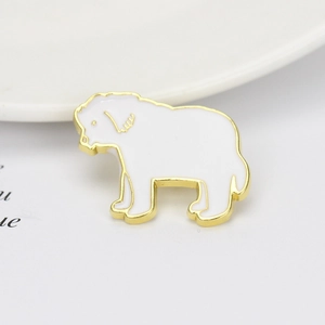 Detailed close-up of a white and gold dog-shaped metal brooch on a clean white background