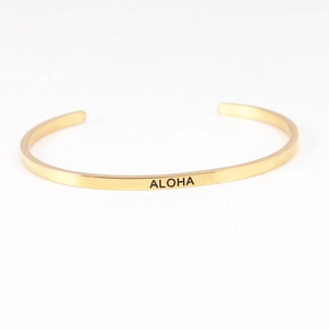 Detailed macro view of the gold-plated Mantra Bracelet with engraved ALOHA lettering