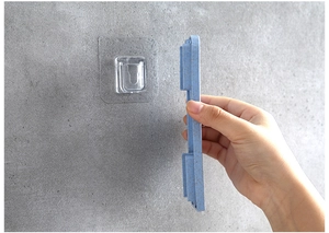 Installing the blue wheat straw soap dish onto a transparent adhesive wall hook