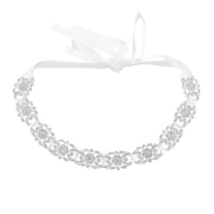 Detail of silver crystal headpiece featuring white satin ribbon and floral rhinestone patterns