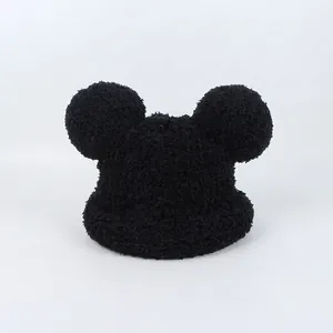 Close-up of black plush winter hat with cute round mouse ears and soft faux fur texture